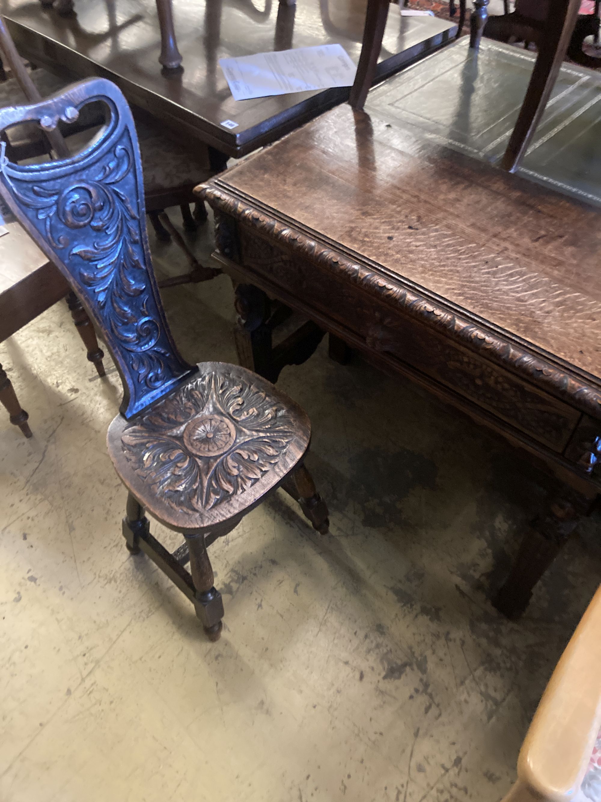 A late 19th century Flemish carved oak side table, width 88cm, depth 42cm, height 76cm, together with a carved oak spinning chair